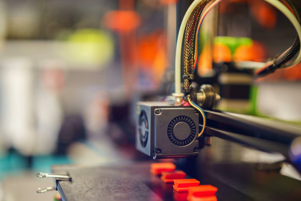 pexels photo 20552667 20552667 Detailed close-up of a 3D printer extruding red plastic during operation.